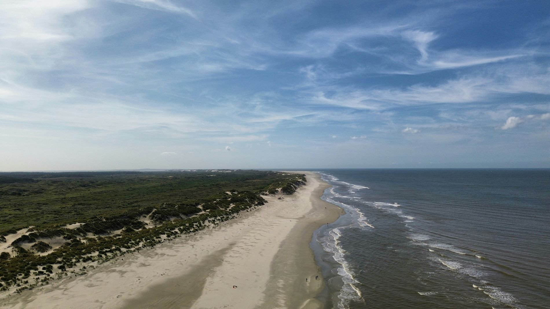 De kust van Terschelling vanuit de lucht, duinen en een breed leeg strand